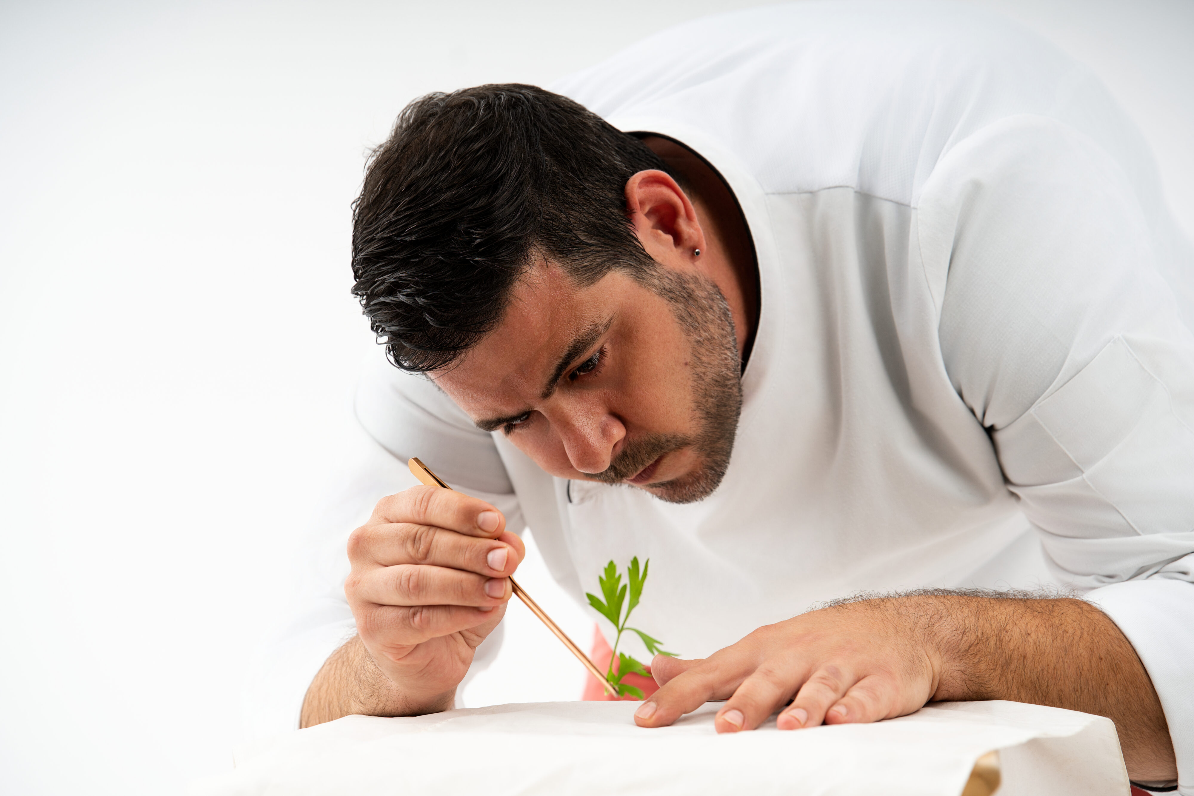 Chef preparando hierbas frescas en cocina de restaurante valenciano — fotografía gastronómica profesional